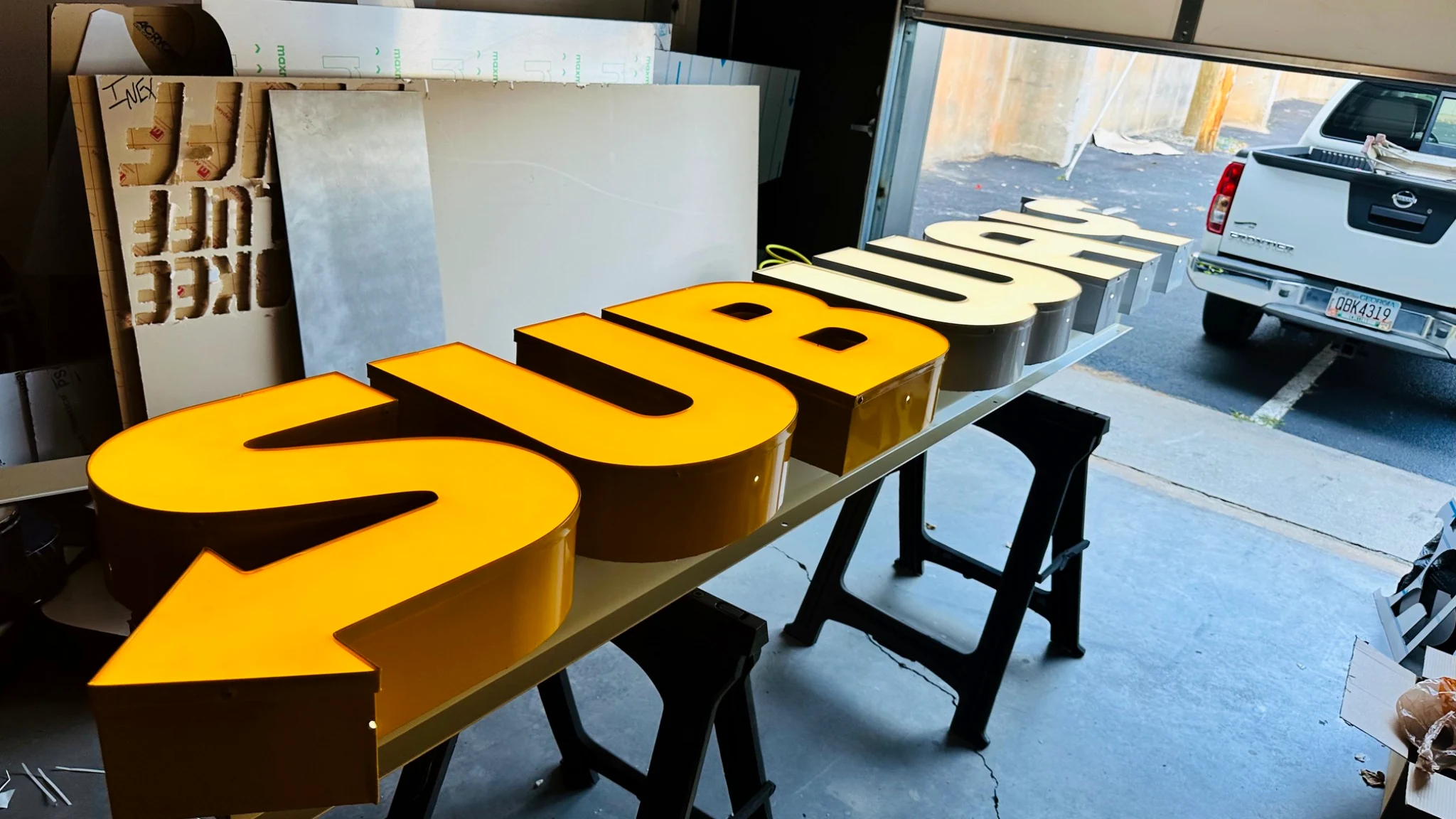 Large custom orange illuminated letters being fabricated